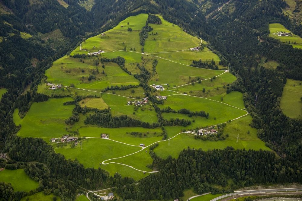 Hopfberg from above - Alpine meadows and scattered houses along a serpentine path in Hopfberg in the state Salzburg in Austria