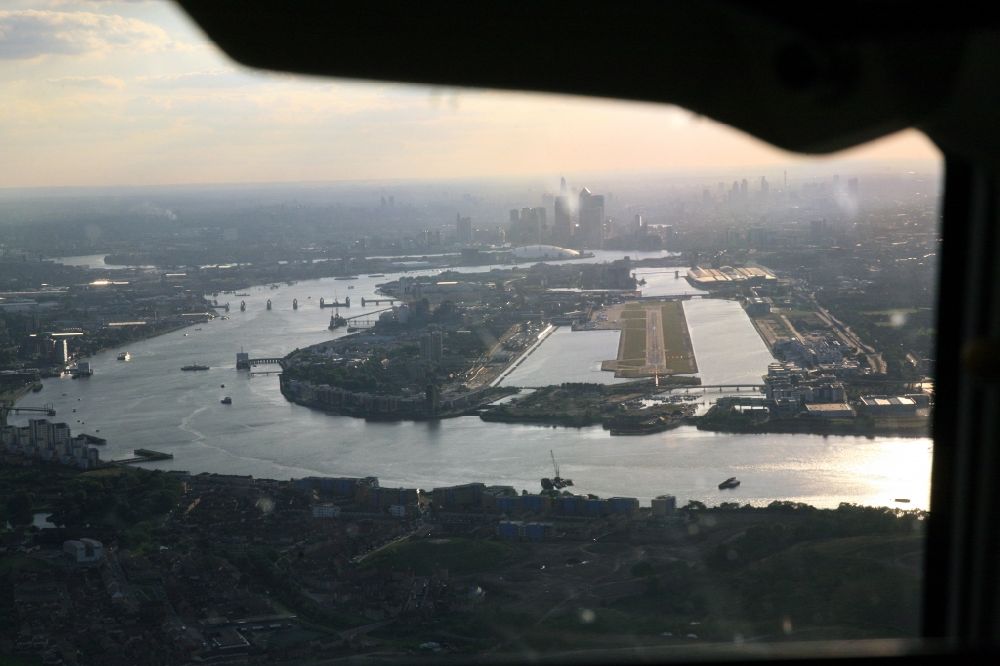 London from the bird's eye view: View from the cockpit while approaching the London City Airport in the Docklands of London in the UK. The commercial airport ( ICAO code : EGLC ) is utilized because of its proximity to the city center and downtown especially for business travel