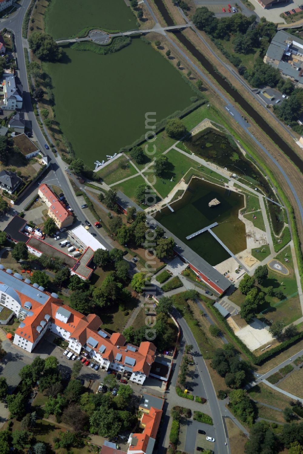 Großenhain from the bird's eye view: Nature outdoor pool in Grossenhain in the state of Saxony. The facilities include several buildings as well as a lake compound and bridges. The pool borders the canal of Roederneugraben