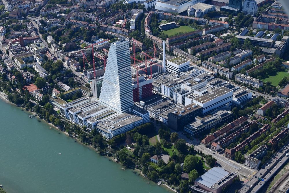 Aerial photograph Basel - Factory premises of the pharmaceutical company Roche with the landmark building and skyscraper in Basle in Switzerland. Construction works for the second high-rise tower are under way