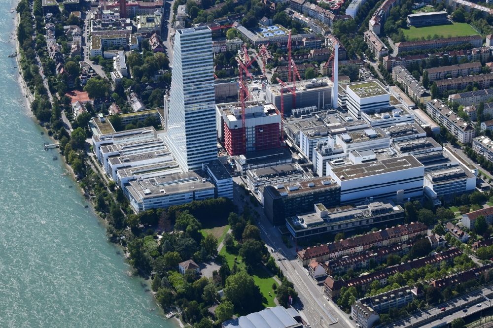 Basel from the bird's eye view: Factory premises of the pharmaceutical company Roche with the landmark building and skyscraper in Basle in Switzerland. Construction works for the second high-rise tower are under way