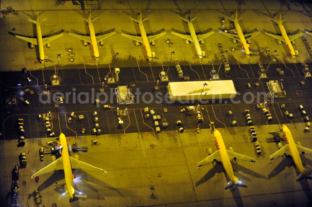 Schkeuditz at night from the bird perspective: Night lighting check-in buildings and cargo terminals on the grounds of the airport on DHL Hub in Schkeuditz in the state Saxony, Germany