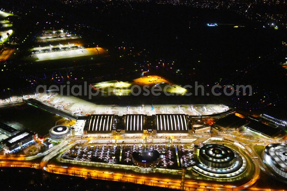 Hamburg at night from the bird perspective: Night lighting dispatch building and terminals on the premises of the airport Hamburg Airport Helmut Schmidt (ICAO-Code:EDDH) in the district Fuhlsbuettel in Hamburg, Germany