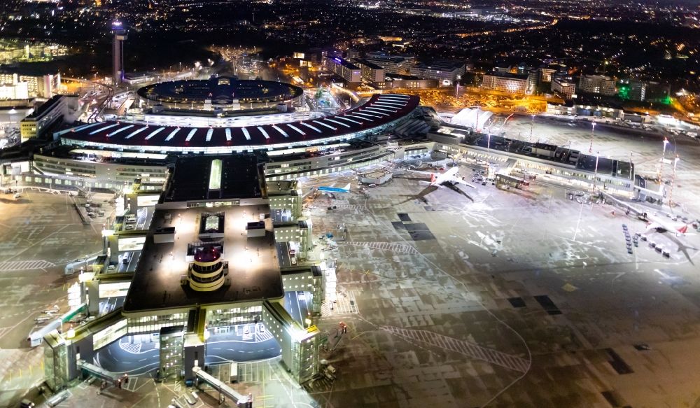 Aerial image at night Düsseldorf - Night lighting dispatch building and terminals on the premises of the airport in Duesseldorf in the state North Rhine-Westphalia, Germany