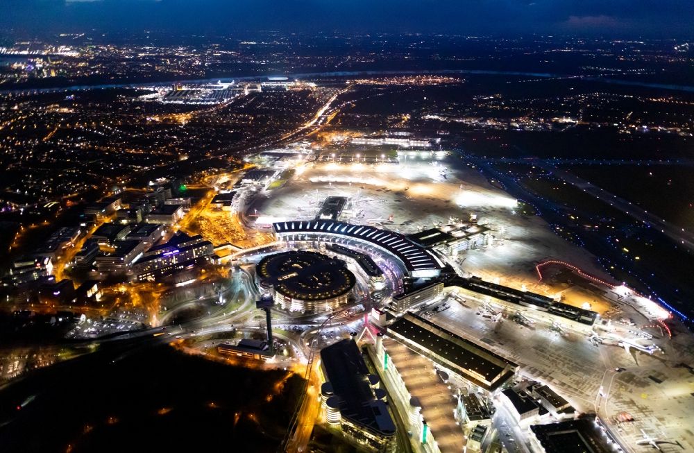 Aerial image at night Düsseldorf - Night lighting dispatch building and terminals on the premises of the airport in Duesseldorf in the state North Rhine-Westphalia, Germany