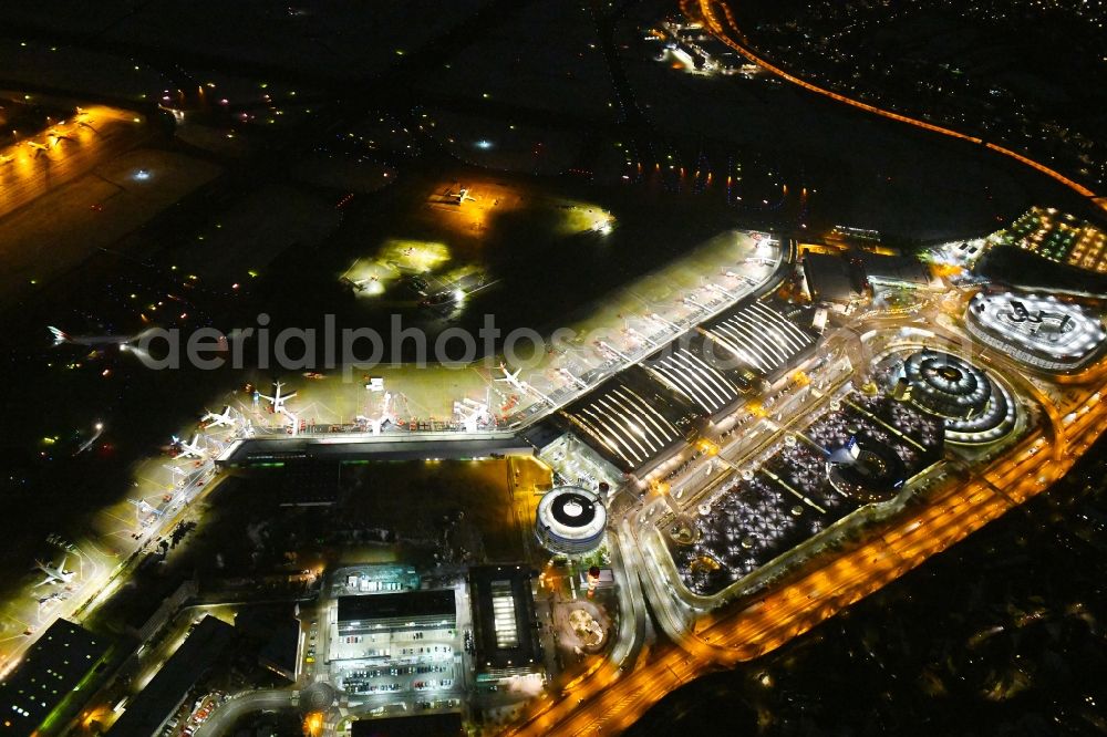 Hamburg at night from the bird perspective: Night lighting dispatch building and terminals on the premises of the airport Hamburg Airport Helmut Schmidt (ICAO-Codea??: a??EDDH) in the district Fuhlsbuettel in Hamburg, Germany