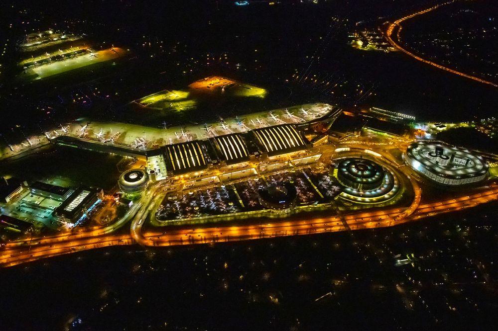 Hamburg at night from the bird perspective: Night lighting dispatch building and terminals on the premises of the airport Hamburg Airport Helmut Schmidt (ICAO-Code EDDH) in the district Fuhlsbuettel in Hamburg, Germany