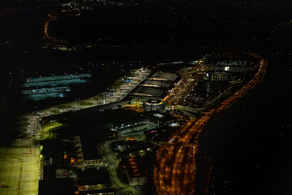 Hamburg at night from the bird perspective: Night lighting dispatch building and terminals on the premises of the airport Hamburg Airport Helmut Schmidt (ICAO-Code EDDH) in the district Fuhlsbuettel in Hamburg, Germany