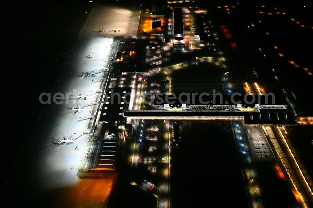 Schkeuditz at night from the bird perspective: Night lighting dispatch building and terminals on the premises of the airport of Flughafen Leipzig/Halle GmbH in Schkeuditz in the state Saxony, Germany