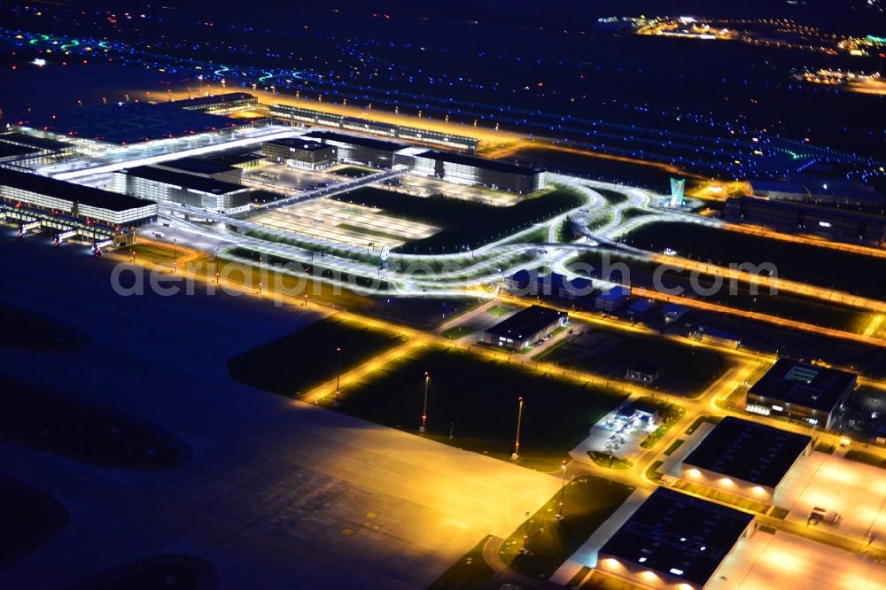 Aerial photograph at night Schönefeld - Night lighting dispatch building and terminals on the premises of the airport BER in Schoenefeld in the state Brandenburg
