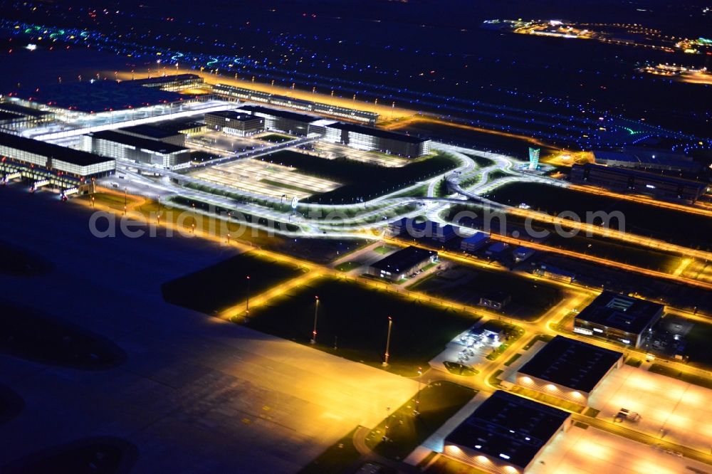 Aerial image at night Schönefeld - Night lighting dispatch building and terminals on the premises of the airport BER in Schoenefeld in the state Brandenburg
