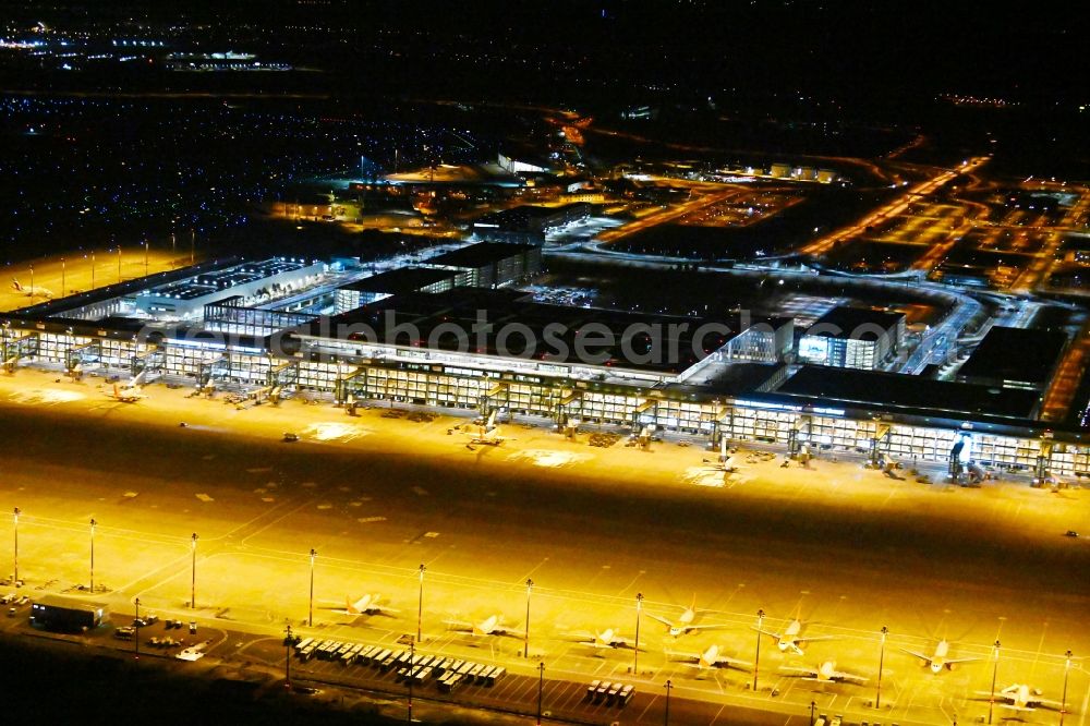 Schönefeld at night from the bird perspective: Night lighting dispatch building and terminals on the premises of the airport BER in Schoenefeld in the state Brandenburg