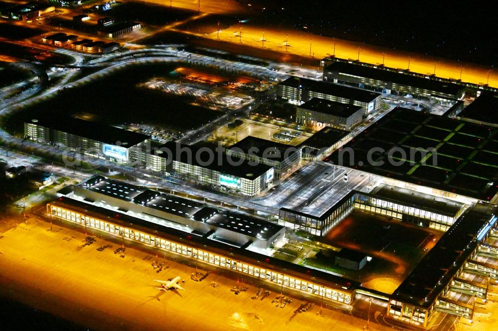 Schönefeld at night from above - Night lighting dispatch building and terminals on the premises of the airport BER in Schoenefeld in the state Brandenburg