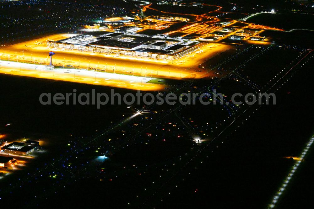 Schönefeld at night from the bird perspective: Night lighting dispatch building and terminals on the premises of the airport BER in Schoenefeld in the state Brandenburg