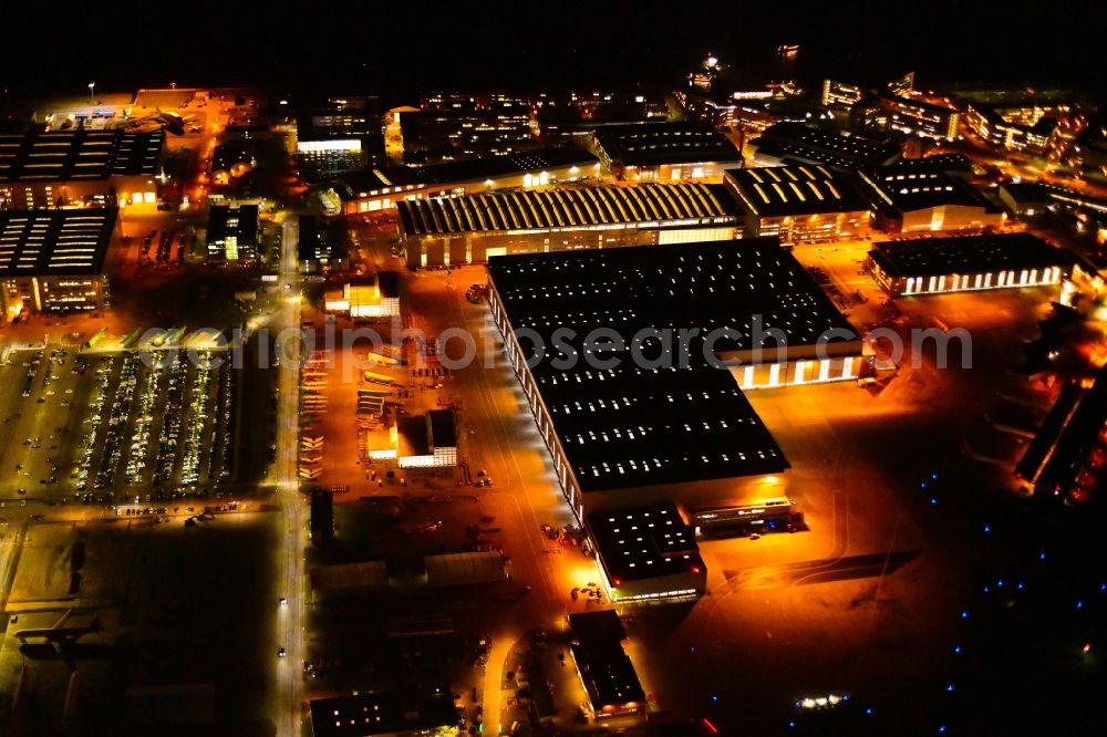 Aerial photograph at night Hamburg - Night lighting airbus works and airport of Finkenwerder in Hamburg in Germany. The former Hamburger Flugzeugbau works - on the Finkenwerder Peninsula on the riverbank of the Elbe - include an Airbus production site with an airplane. Several Airbus planes and models are being constructed here
