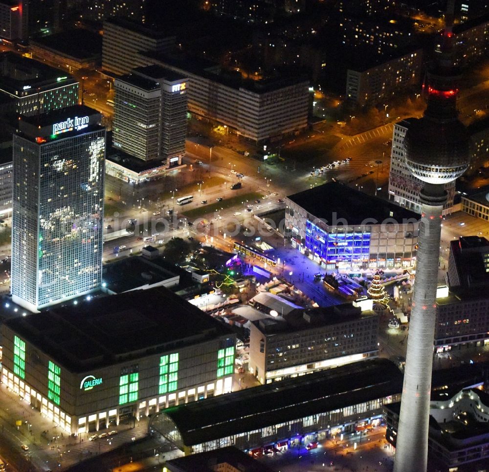 Aerial photograph at night Berlin - Night view overlooking illuminated buildings at Alexanderplatz in the center of Berlin. Visible among others are the shopping centre Galeria Kaufhof as well as the Park Inn Hotel and the television tower