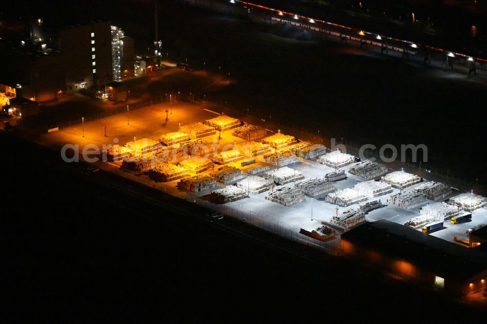 Aerial image at night Eisenhüttenstadt - Night lighting View at Waste paper stacks on the plant grounds of the factory for corrugated base paper Propapier plant PM2 GmbH in Eisenhuettenstadt in Brandenburg