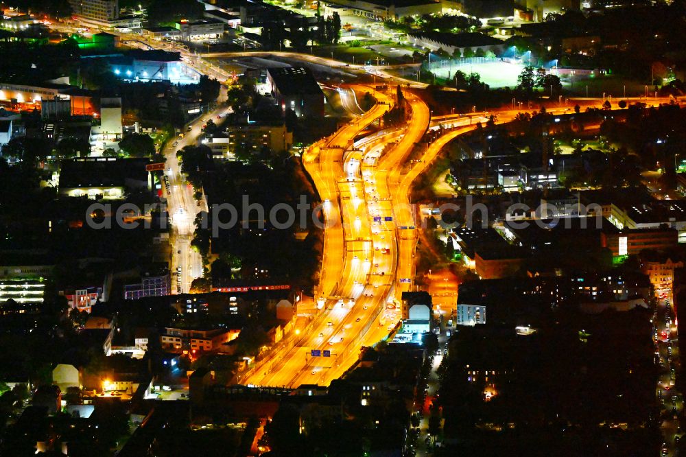 Berlin at night from the bird perspective: Night view routing and traffic lanes during the highway exit and access the motorway A 100 - 113 Grenzallee destrict Neukoelln in Berlin
