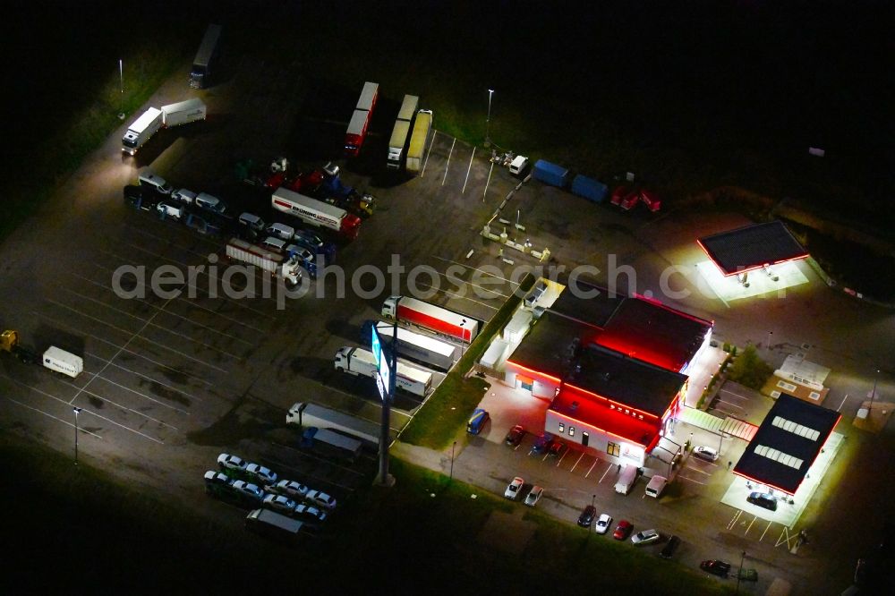 Landsberg at night from above - Night lighting Routing and traffic lanes during the motorway service station and parking lot of the BAB A 14 TOTAL Autohof in Landsberg in the state Saxony-Anhalt, Germany