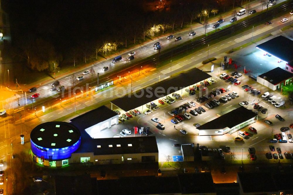 Aerial photograph at night Berlin - Night lighting car dealership building PEUGEOT PSA RETAIL on Blumberger Donm corner Landsberger Allee in the district Marzahn in Berlin, Germany