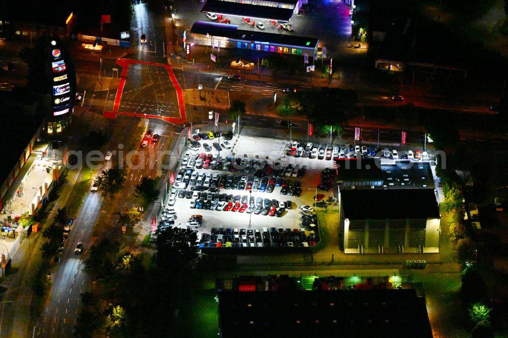 Berlin at night from the bird perspective: Night lighting car dealership building of Autoland AG on street Nonnendammallee in the district Spandau in Berlin, Germany