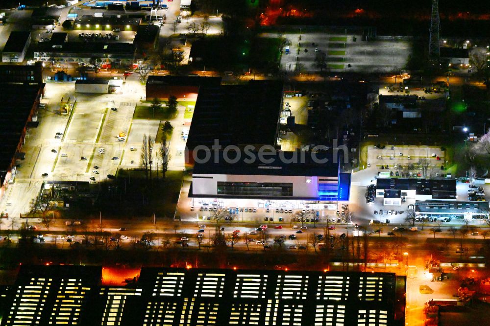 Aerial image at night Berlin - Night lighting car dealership building BMW Autohaus Nefzger on street Nonnendammallee in the district Siemensstadt in Berlin, Germany