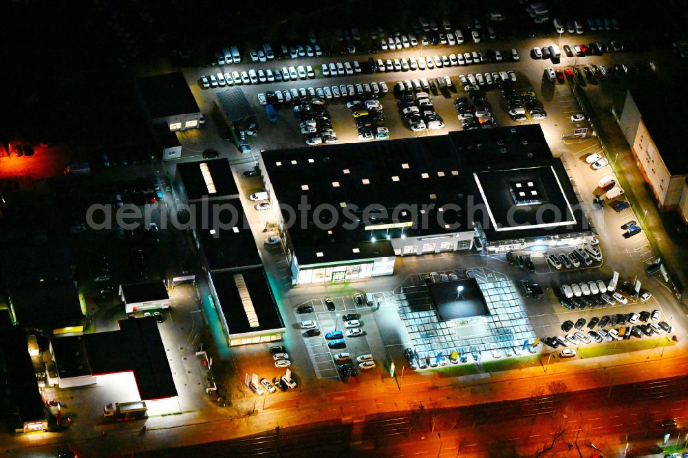 Aerial image at night Berlin - Night lighting car dealership building MOeBUS on street Hansastrasse in the district Weissensee in Berlin, Germany