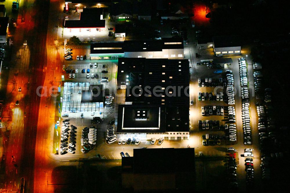 Berlin at night from the bird perspective: Night lighting car dealership building MOeBUS on street Hansastrasse in the district Weissensee in Berlin, Germany