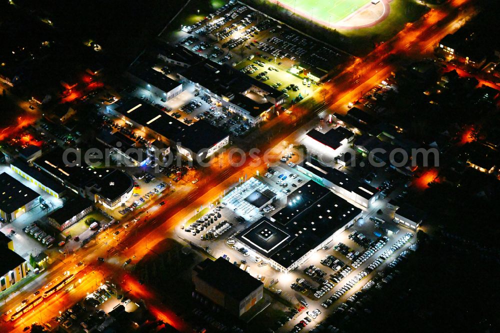 Berlin at night from the bird perspective: Night lighting car dealership building MOeBUS on street Hansastrasse in the district Weissensee in Berlin, Germany