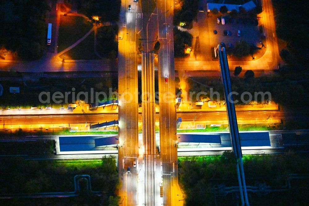 Aerial image at night Berlin - Night lighting station building and track systems of the S-Bahn station on bridge street Falkenberger Chaussee in the district Hohenschoenhausen in Berlin, Germany