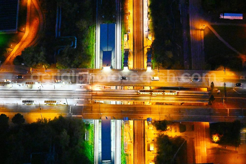 Aerial photograph at night Berlin - Night lighting station building and track systems of the S-Bahn station on bridge street Falkenberger Chaussee in the district Hohenschoenhausen in Berlin, Germany