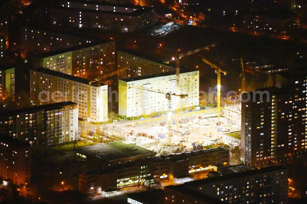 Berlin at night from the bird perspective: Night lighting Construction site to build a new multi-family residential complex Dolgensee-Center on Dolgenseestrasse in the district Lichtenberg in Berlin, Germany