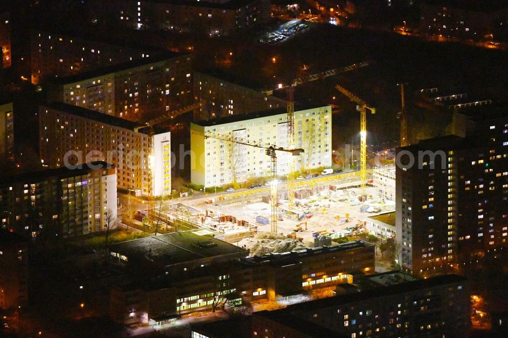 Aerial image at night Berlin - Night lighting Construction site to build a new multi-family residential complex Dolgensee-Center on Dolgenseestrasse in the district Lichtenberg in Berlin, Germany