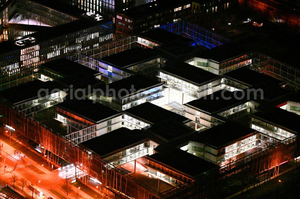 München at night from the bird perspective: Night lighting office building of Allianz Deutschland AG on Dieselstrasse in Unterfoehring in the state Bavaria, Germany