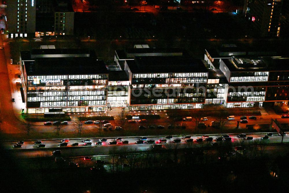 München at night from the bird perspective: Night lighting office building of Microsoft Deutschland GmbH on street Walter-Gropius-Strasse in the district Freimann in Munich in the state Bavaria, Germany