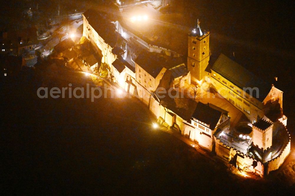 Aerial image at night Eisenach - Night lighting castle of the fortress Wartburg-Stiftung Eisenach in Eisenach in the Thuringian Forest in the state Thuringia, Germany