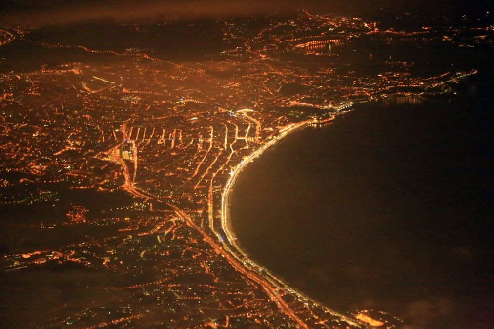 Nizza at night from the bird perspective: Night lighting of the city lights at the bay along the sea coast Promenade of Anglais at the Mediterranean Sea in Nice in Provence-Alpes-Cote d'Azur, France