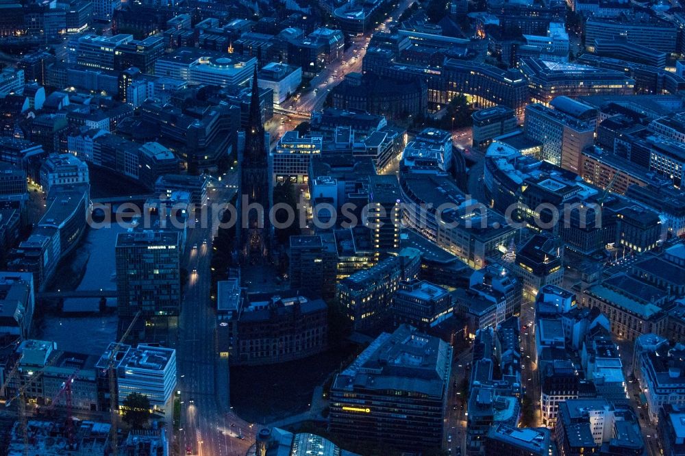 Aerial image at night Hamburg - Night aerial view of the memorial site of St. Nikolai in Hamburg. The St. Nikolai Memorial is a place to remember the victims of war and tyranny of the years 1933-1945. The building served as the main Protestant church in Hamburg before it was destroyed during the air raids of 1943. Today a museum that deals with the causes and consequences of the war is located inside the ruin