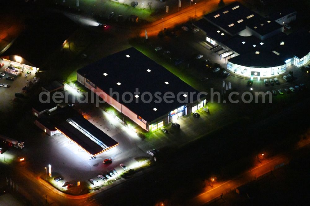 Aerial photograph at night Wittstock/Dosse - Night aerial view of the gas station and the building complex of the Home Market Wittstock in Wittstock / Dosse in the state of Brandenburg, Germany