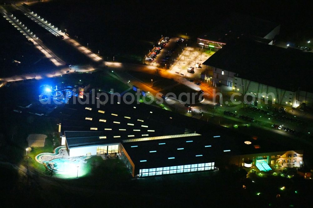 Wolfsburg at night from the bird perspective: Night lighting Spa and swimming pools at the swimming pool of the leisure facility BadeLand on Allerpark in Wolfsburg in the state Lower Saxony, Germany