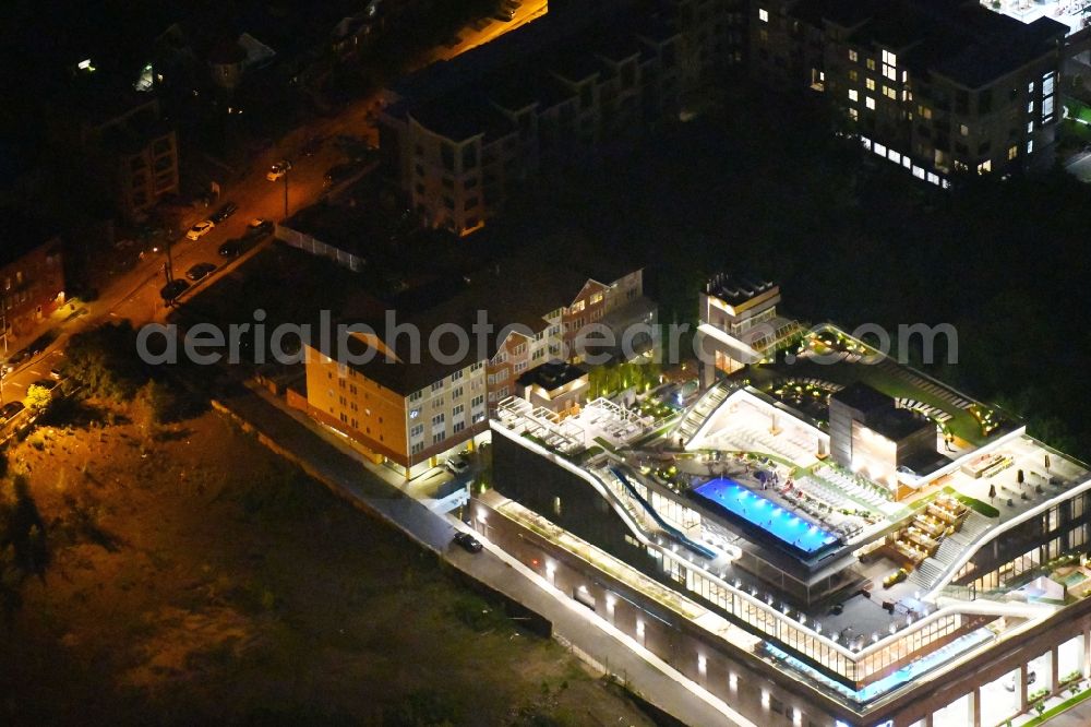 Aerial image at night Edgewater - Night lighting Spa and swimming pools at the swimming pool of the leisure facility SoJo Spa Club on River Road in Edgewater in New Jersey, United States of America