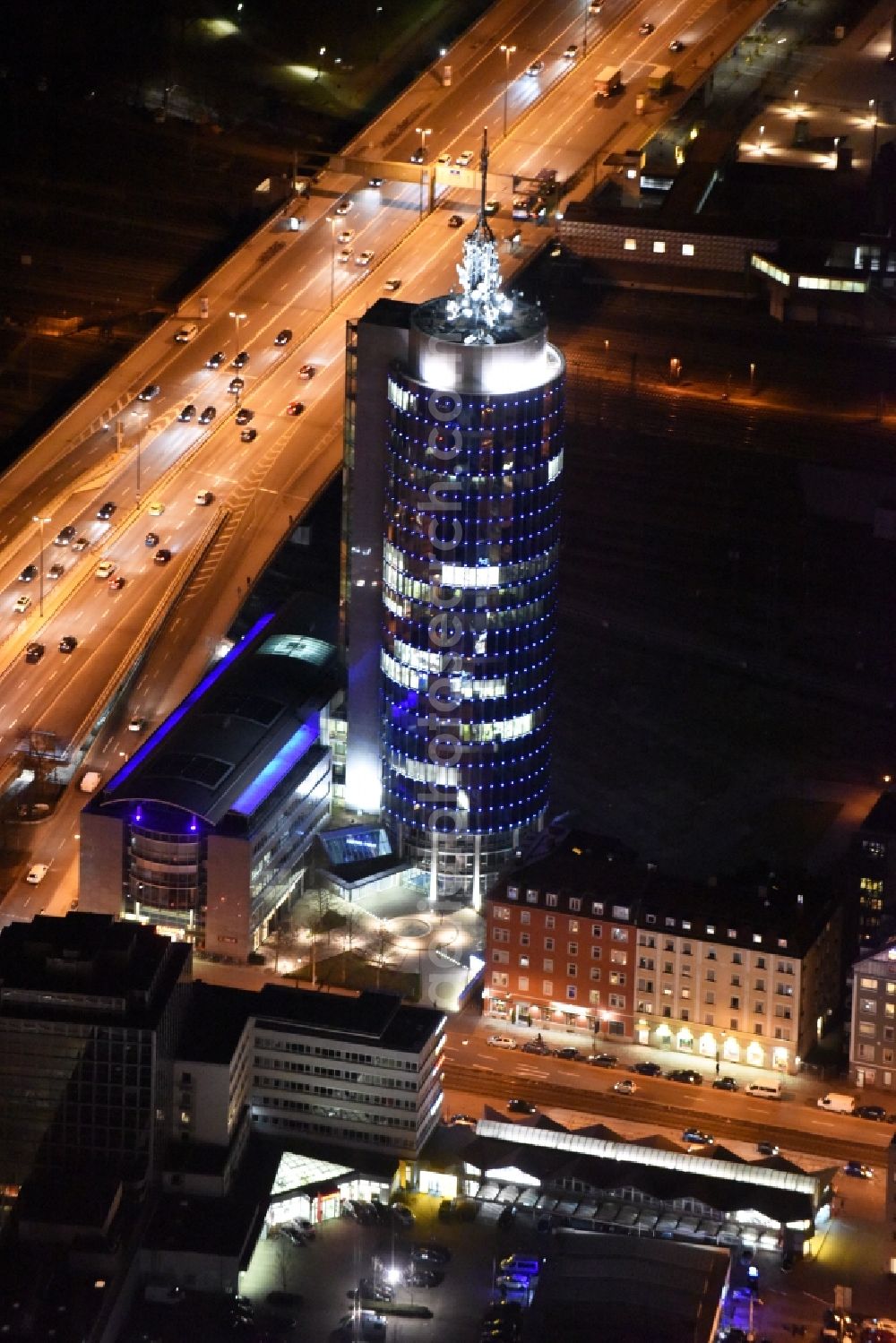 Aerial image at night München - Night aerial view of the blue illuminated skyscraper Central Tower in Munich in Bavaria