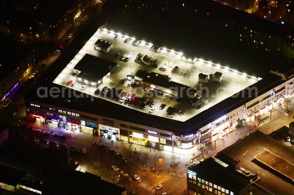 Berlin at night from the bird perspective: Night lighting shopping center on Elcknerplatz at Berlin - Koepenick