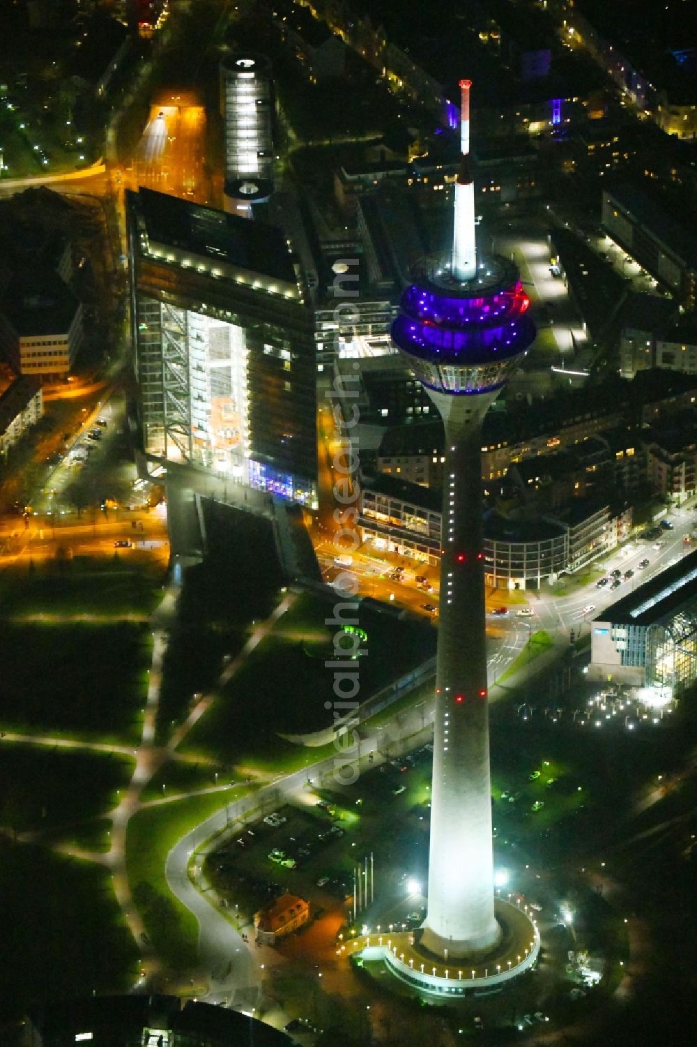 Aerial photograph at night Düsseldorf - Night lighting top of the Television Tower Rheinturm with the city center in the background in Duesseldorf in the state North Rhine-Westphalia