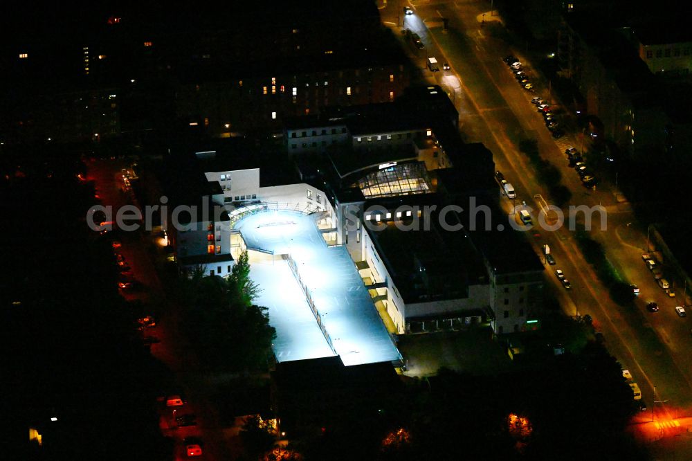Berlin at night from the bird perspective: Night lighting building of the shopping center Neumann Forum on street Neumannstrasse in the district Pankow in Berlin, Germany