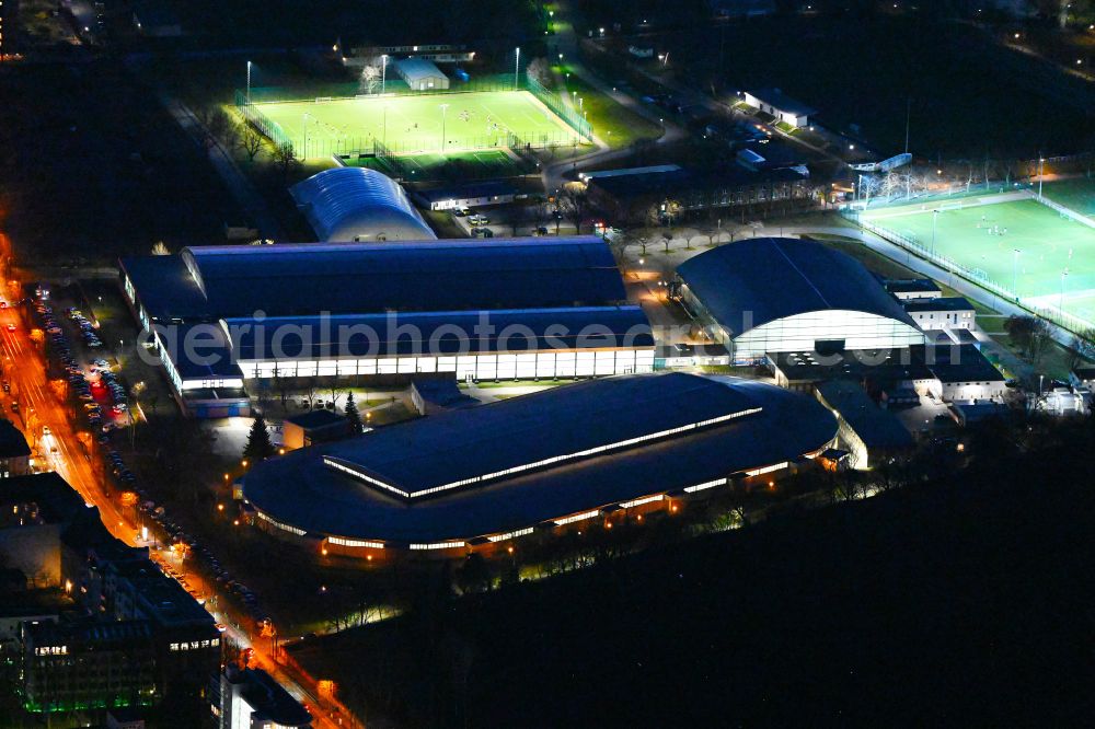 Berlin at night from the bird perspective: Night lighting ensemble of sports grounds and Eisschnelllaufhalle in Sportforum Berlin Konrad-Wolf-Strasse in the district Hohenschoenhausen in Berlin, Germany