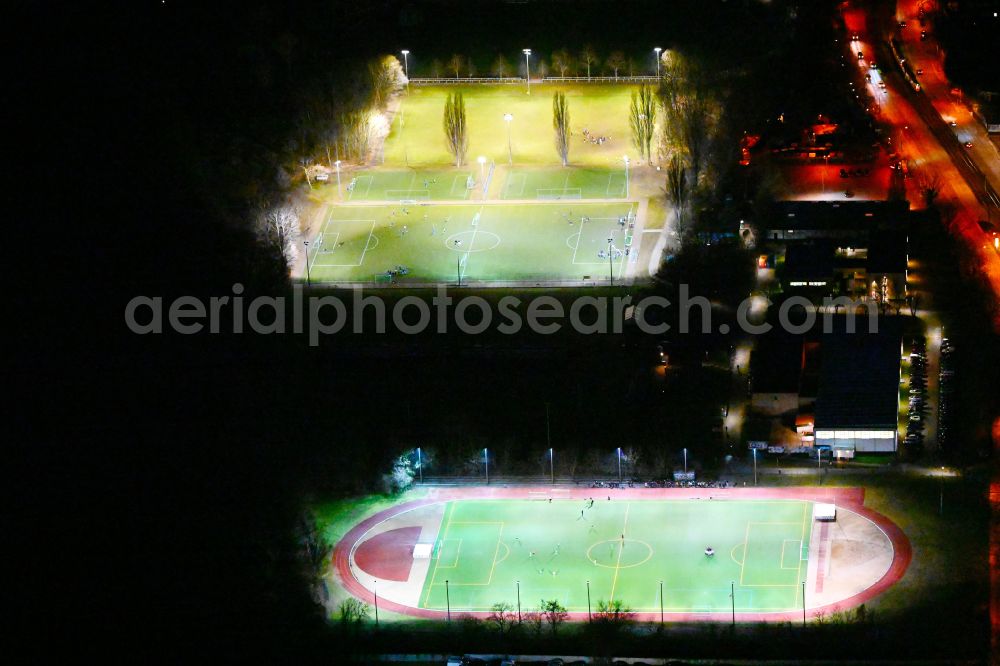Berlin at night from the bird perspective: Night lighting ensemble of sports grounds Stadion Buschallee on street Hansastrasse in the district Weissensee in Berlin, Germany