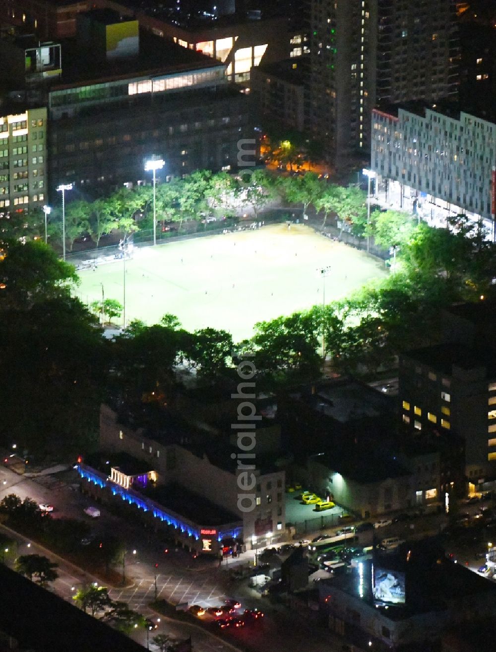 New York at night from above - Night lighting Ensemble of sports grounds De Witt Clinton Park in the district Manhattan in New York in United States of America. In the foreground the Larry Flynt's Hustler Club at the 51st