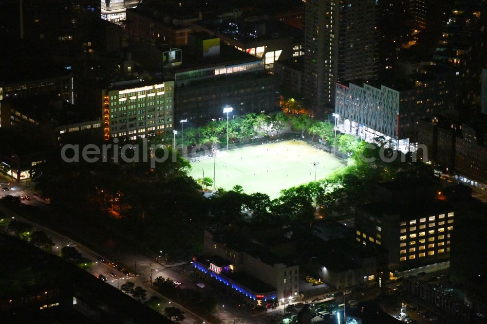 New York at night from the bird perspective: Night lighting Ensemble of sports grounds De Witt Clinton Park in the district Manhattan in New York in United States of America. In the foreground the Larry Flynt's Hustler Club at the 51st