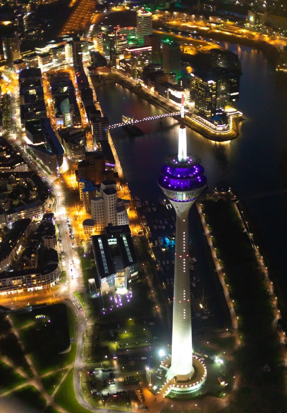 Aerial image at night Düsseldorf - Night lighting top of the Television Tower Rheinturm with the city center in the background in Duesseldorf in the state North Rhine-Westphalia